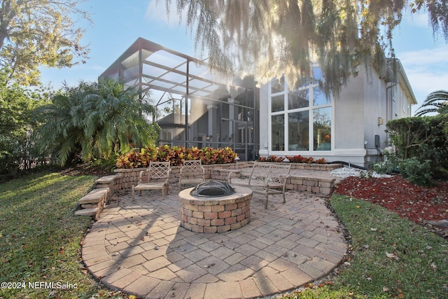 view of patio featuring glass enclosure and a fire pit