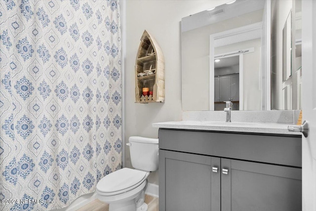 bathroom with vanity, a shower with shower curtain, and toilet