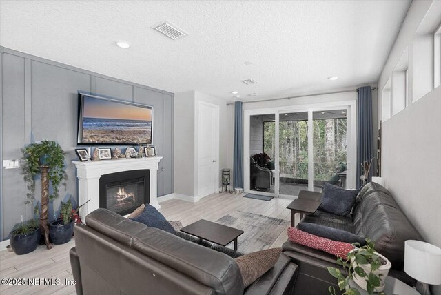 living room featuring light hardwood / wood-style floors and a textured ceiling