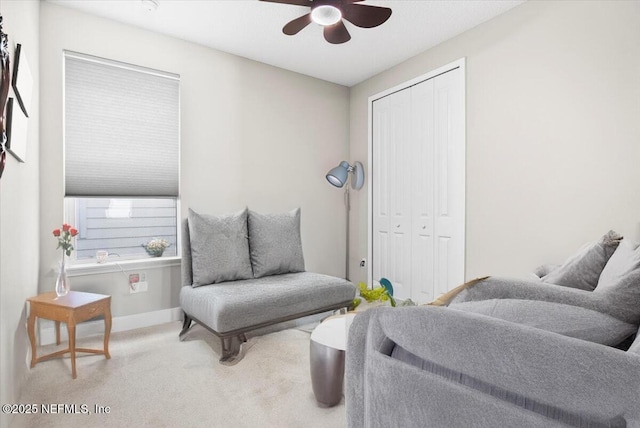 living area with ceiling fan, baseboards, and carpet flooring