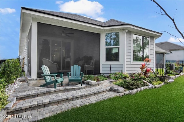 rear view of property featuring a yard, a patio area, and a sunroom