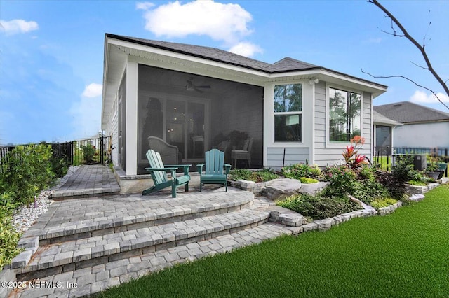 back of property featuring a yard, a patio area, and a sunroom