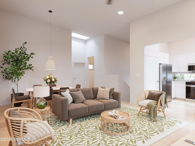 living room with a high ceiling and light hardwood / wood-style flooring