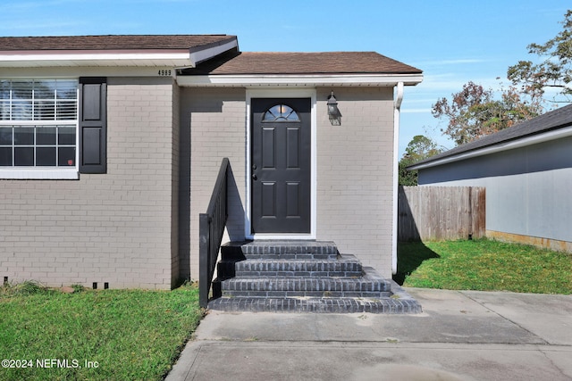 property entrance with a lawn