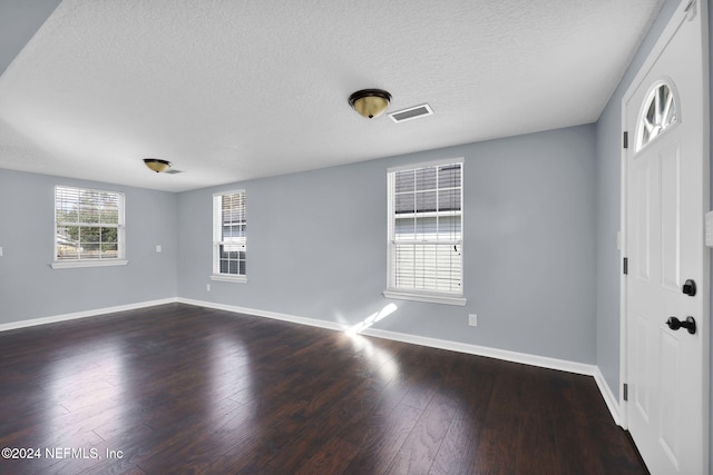 spare room with dark wood-type flooring and a textured ceiling