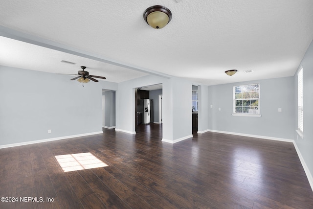 unfurnished living room with ceiling fan, dark wood-type flooring, and a textured ceiling