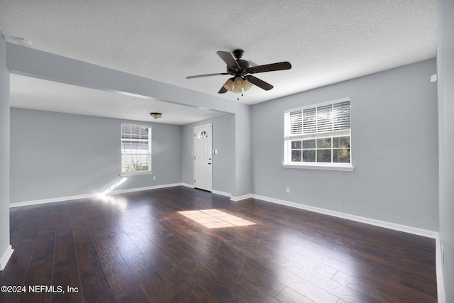 unfurnished room with a textured ceiling, dark hardwood / wood-style floors, and ceiling fan