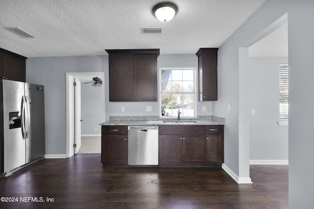 kitchen with ceiling fan, sink, light stone counters, and stainless steel appliances