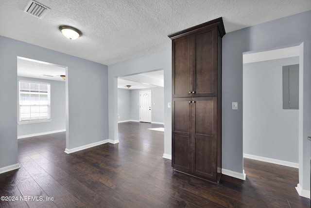 interior space featuring dark wood-type flooring and a textured ceiling