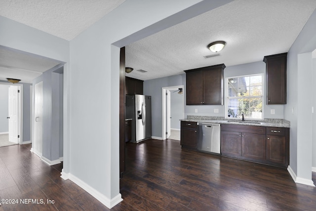 kitchen with sink, stainless steel appliances, dark brown cabinets, and dark wood-type flooring