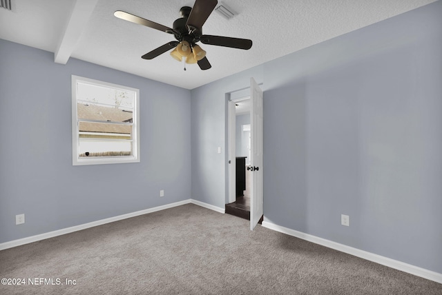 carpeted empty room with a textured ceiling, beam ceiling, and ceiling fan