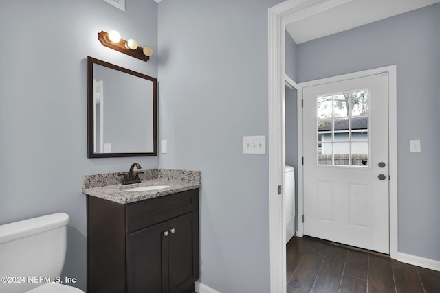 bathroom featuring wood-type flooring, toilet, and vanity