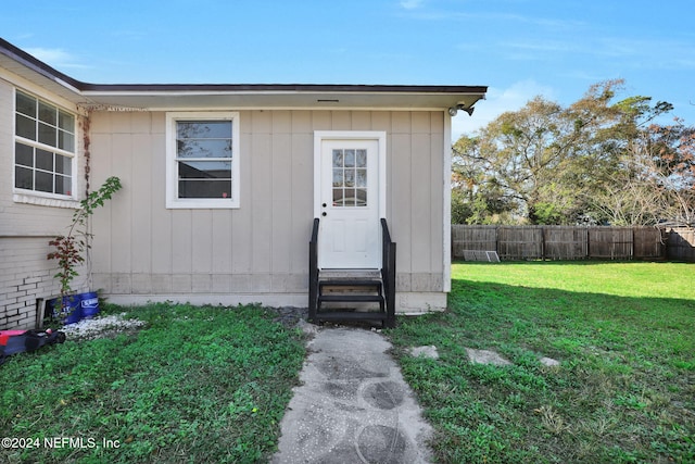 property entrance featuring a lawn