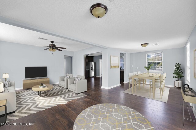 living room with a textured ceiling and dark hardwood / wood-style flooring