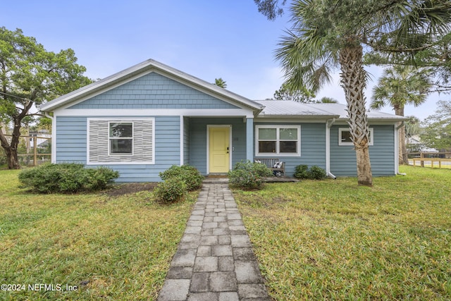 bungalow-style home featuring a front lawn