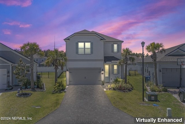 front of property with a garage and a yard