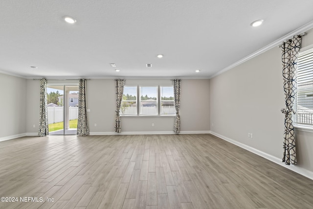 spare room with light hardwood / wood-style flooring and crown molding