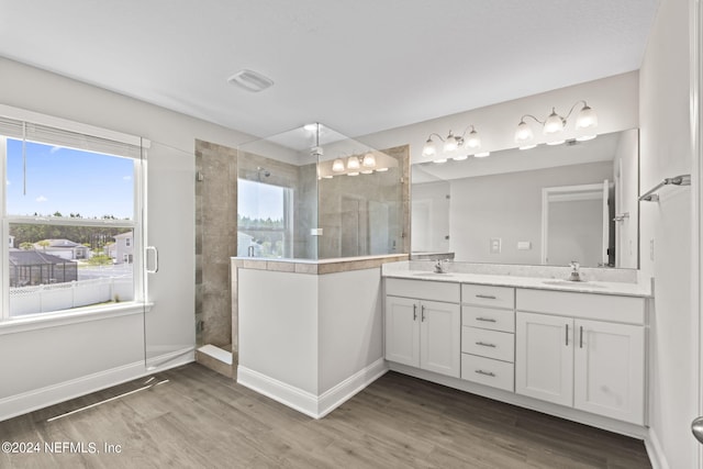 bathroom featuring hardwood / wood-style floors, vanity, and a tile shower