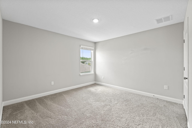 spare room featuring a textured ceiling and carpet floors