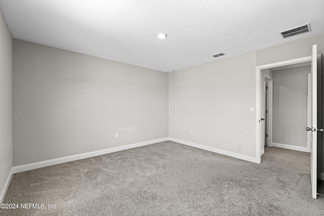 unfurnished room featuring a textured ceiling and carpet floors