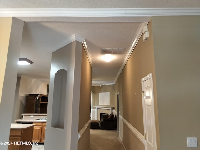 hall with light colored carpet and crown molding