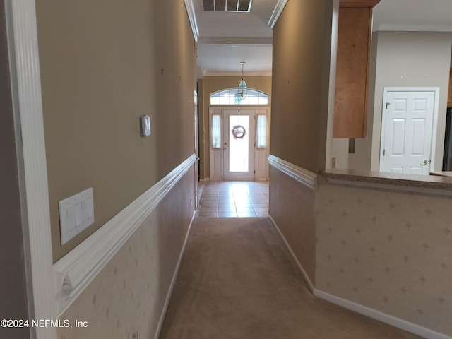 doorway with carpet floors and ornamental molding