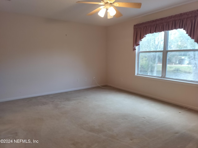 carpeted empty room featuring ceiling fan