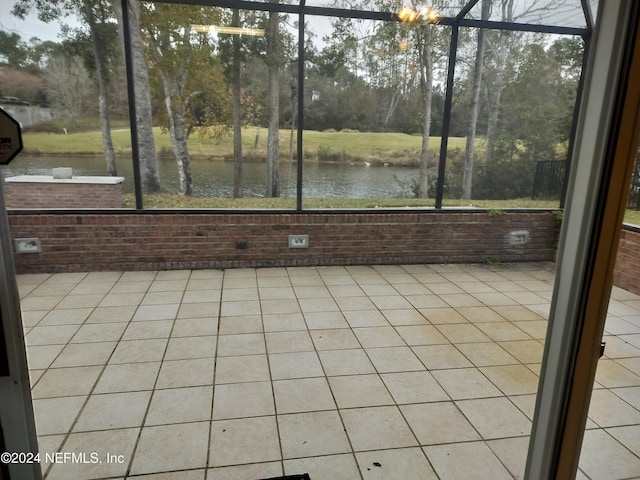 unfurnished sunroom with a water view and a chandelier