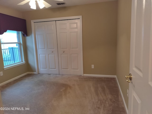 unfurnished bedroom featuring carpet floors, a closet, and ceiling fan