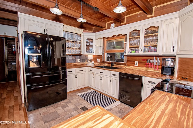 kitchen with wooden counters, pendant lighting, sink, and black appliances