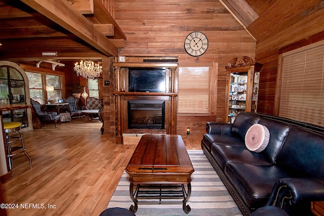 unfurnished living room with vaulted ceiling with beams, wood-type flooring, wooden walls, and a chandelier