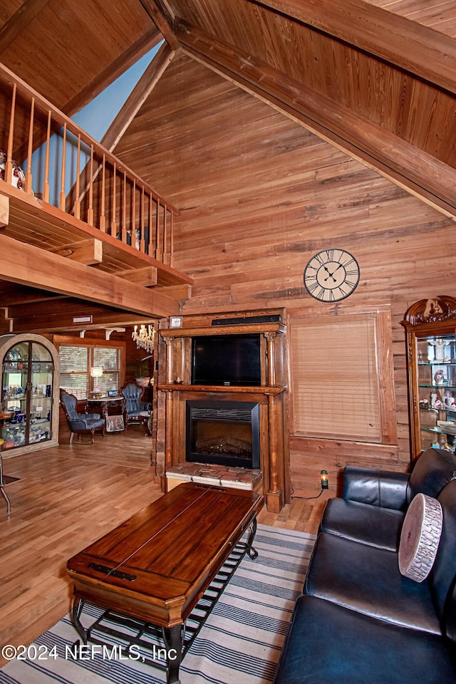 unfurnished living room with hardwood / wood-style floors, wooden ceiling, high vaulted ceiling, and wooden walls