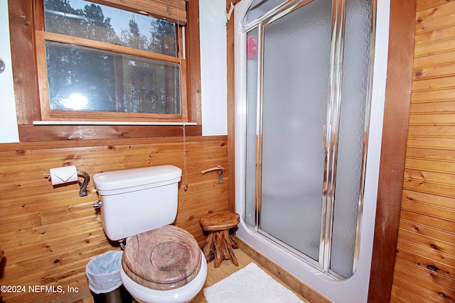 bathroom featuring toilet, walk in shower, and wooden walls