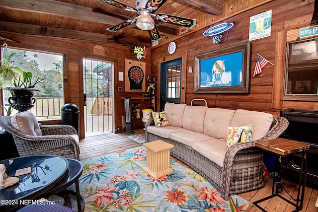 living room featuring vaulted ceiling with beams, light hardwood / wood-style flooring, and wooden ceiling