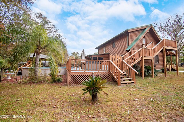 back of house featuring a wooden deck and a yard