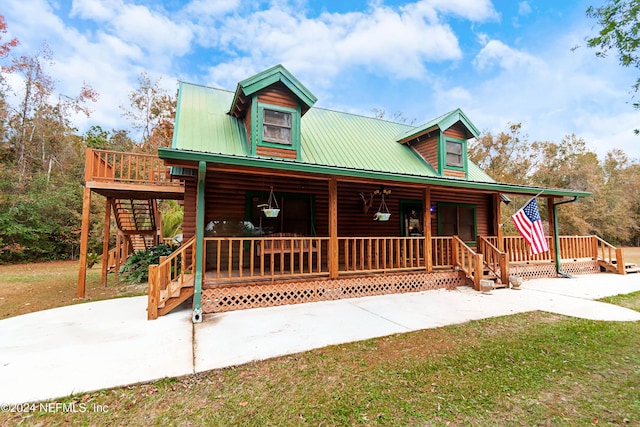 log-style house featuring a front lawn and covered porch