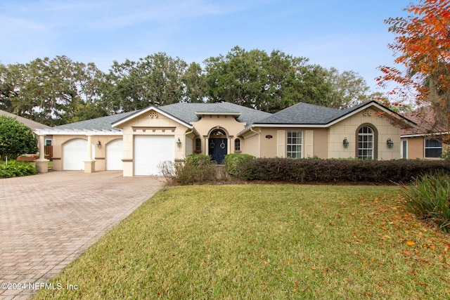 single story home featuring a garage and a front yard