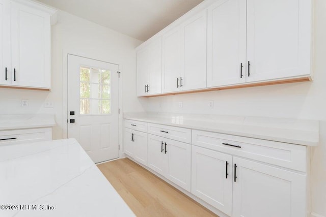 clothes washing area with light hardwood / wood-style flooring