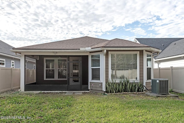 rear view of property with a lawn, central AC, and a sunroom