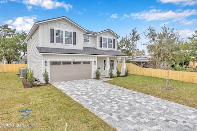 view of front of house featuring central AC unit, a garage, and a front yard