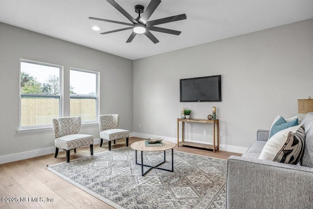 living room featuring ceiling fan and light hardwood / wood-style flooring