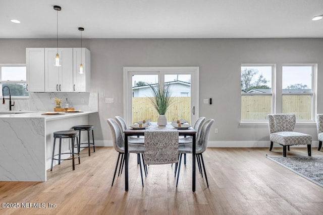 dining room with light hardwood / wood-style floors and sink