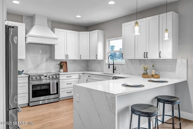 kitchen with stainless steel appliances, custom range hood, and white cabinets