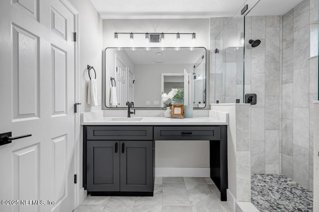 bathroom featuring tiled shower and vanity