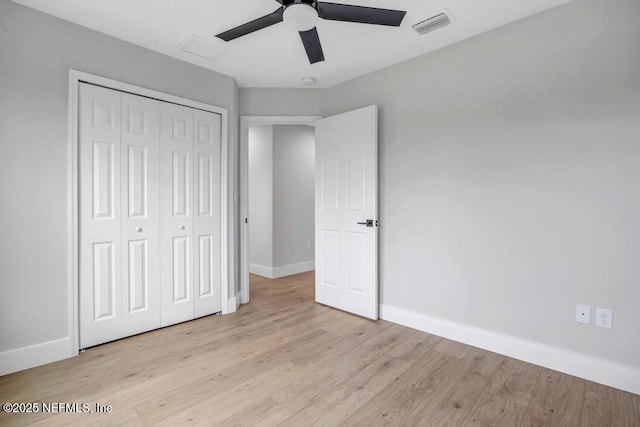 unfurnished bedroom with light hardwood / wood-style flooring, ceiling fan, and a closet