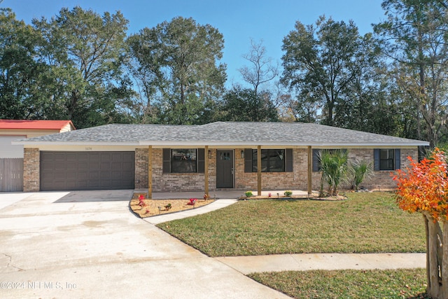 ranch-style home with covered porch, a garage, and a front lawn