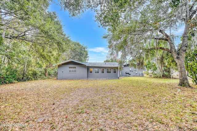 rear view of property featuring a lawn