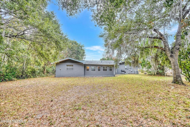 1 Farrington Ln, Palm Coast, FL 32137 - rear view of house with a lawn and stucco siding