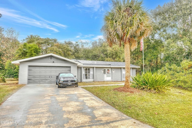 ranch-style home with solar panels, a garage, and a front lawn