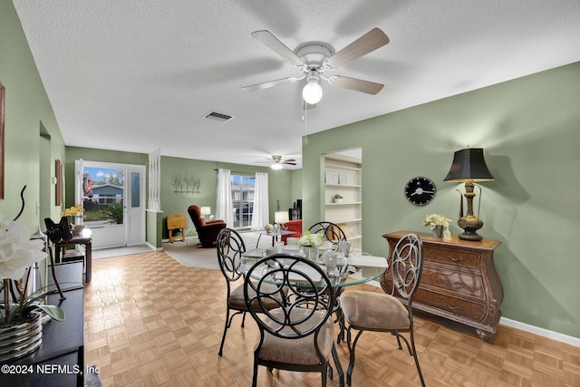 dining room featuring light parquet floors and a textured ceiling